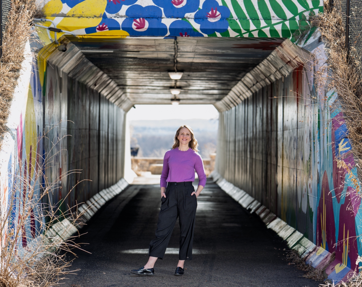 Eden Prairie artist Jenna Myrland is surrounded by the mural she painted with assistance from PiM Arts High School students. The mural is a permanent installation in the Eden Prairie public art collection and was installed in 2019. Photo by Jeremy Peyer