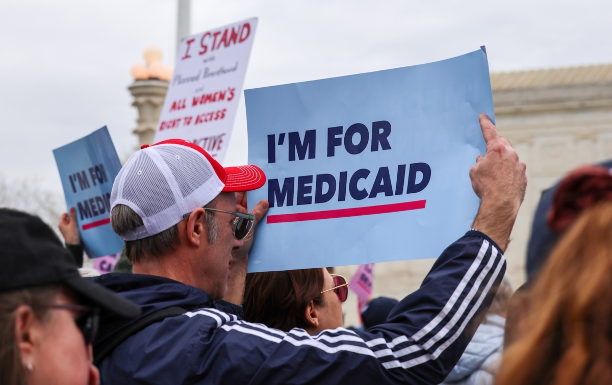 A protester holds a sign in support of Medicaid at a rally outside the U.S. Supreme Court on April 2, 2025. Minnesota's Department of Human Services budget is being crafted despite some uncertainty over how federal cuts could affect the state.