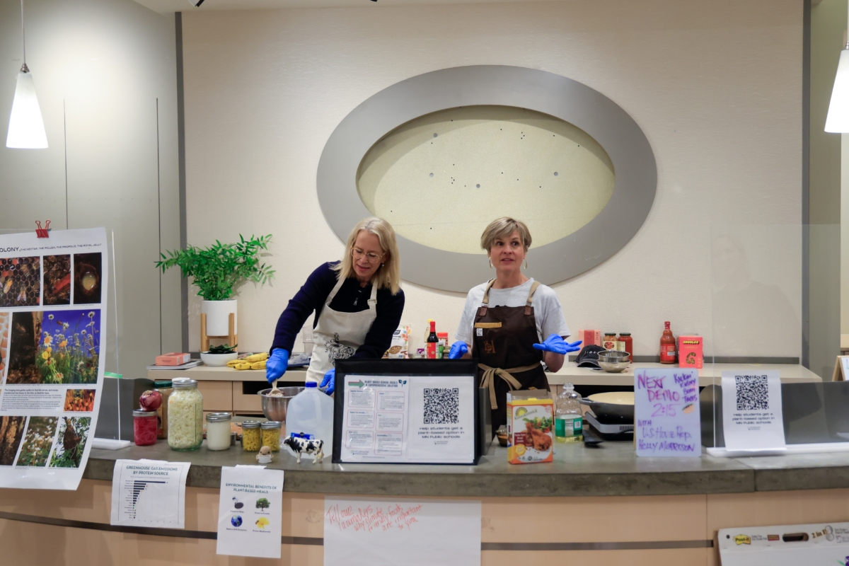 Two women do a cooking demonstration.