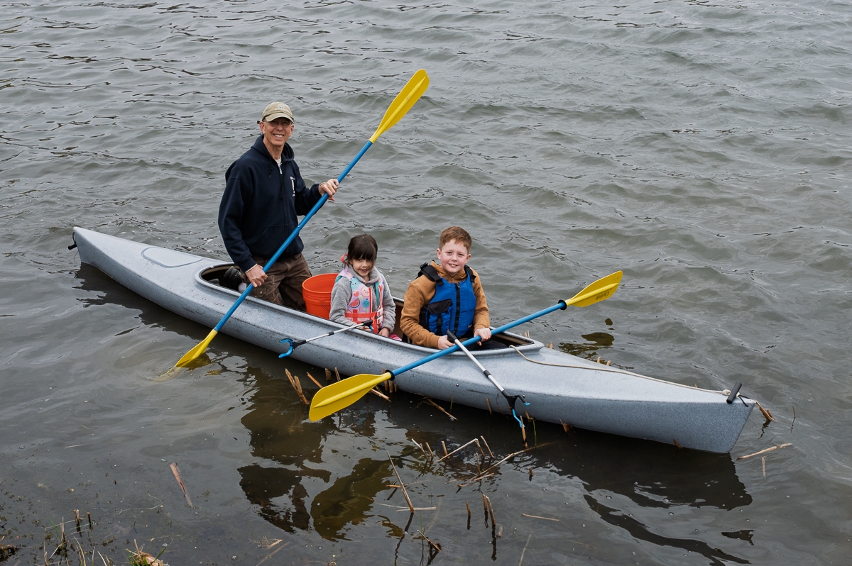 Rod Fischer (left) and his grandchildren, Olive and Levi Brocesky, cleaning up debris via kayak.