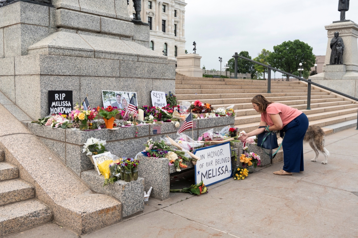 A person leaves flowers at a memorial honoring murdered Democratic state assemblywoman Melissa Hortman and her husband Mark at the State Capitol, in St. Paul, Minnesota, U.S., June 15, 2025.   REUTERS/Tim Evans