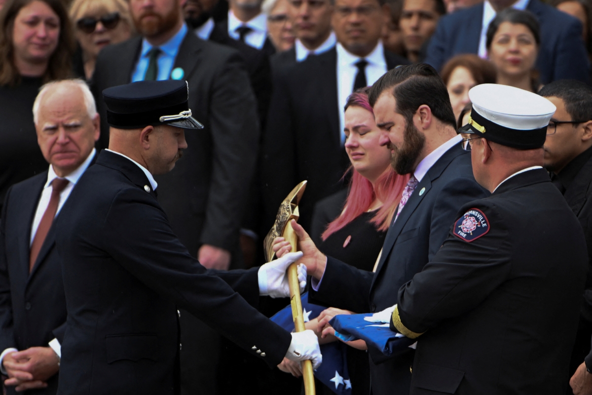 Colin Hortman, son of slain Minnesota lawmaker Melissa Hortman and her husband Mark, is presented a ceremonial firefighter ax after the funeral, two weeks after they were killed by a man impersonating a police officer, at the Basilica of Saint Mary's in Minneapolis, Minnesota, U.S. June 28, 2025.  REUTERS/Craig Lassig