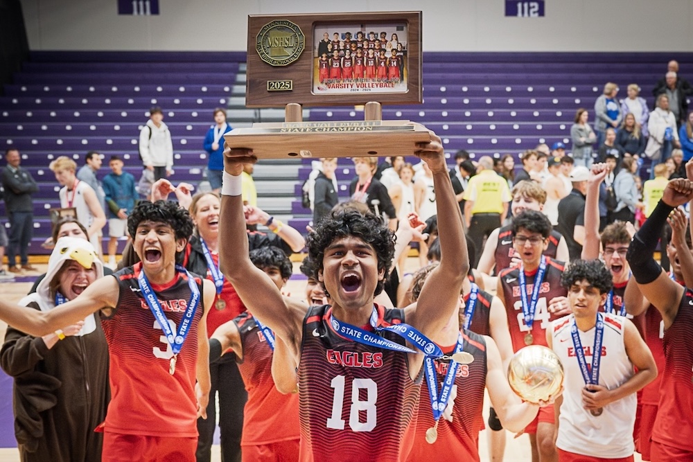 Senior captain Hardhik “Avi” Kommalapati (center) and his teammates celebrate with the first-ever MSHSL boys volleyball state championship trophy Thursday night at St. Thomas’ Schoenecker Arena. The Eagles completed a stunning reverse sweep, overcoming a 2-0 set deficit to defeat Rogers 3-2 and claim the inaugural sanctioned title. Photos by Jeremy Peyer