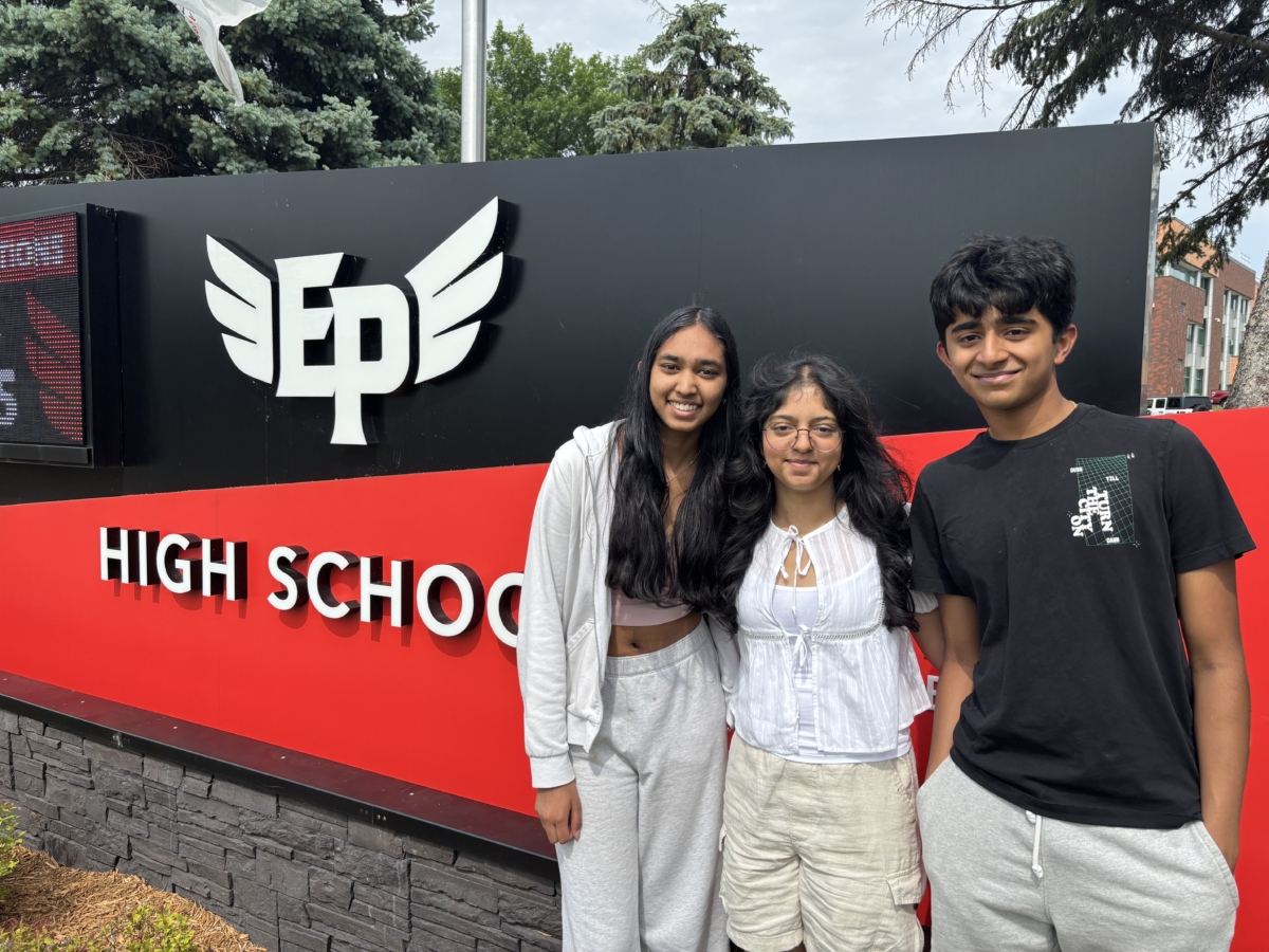 Janika Kannappaganesh, Akshata Guruprasad, and Shikrishnan (Krish) Narayanan standing in front of EPHS sign