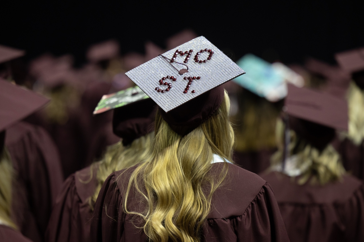 back of head of woman in graduation gown and mortarboard