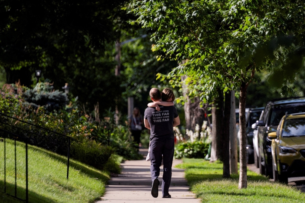 A father carries his daughter, as they walk towards their vehicle after a shooting at Annunciation Church, which is also home to an elementary school, in Minneapolis, Minnesota, U.S. August 27, 2025.  REUTERS/Ben Brewer
     TPX IMAGES OF THE DAY