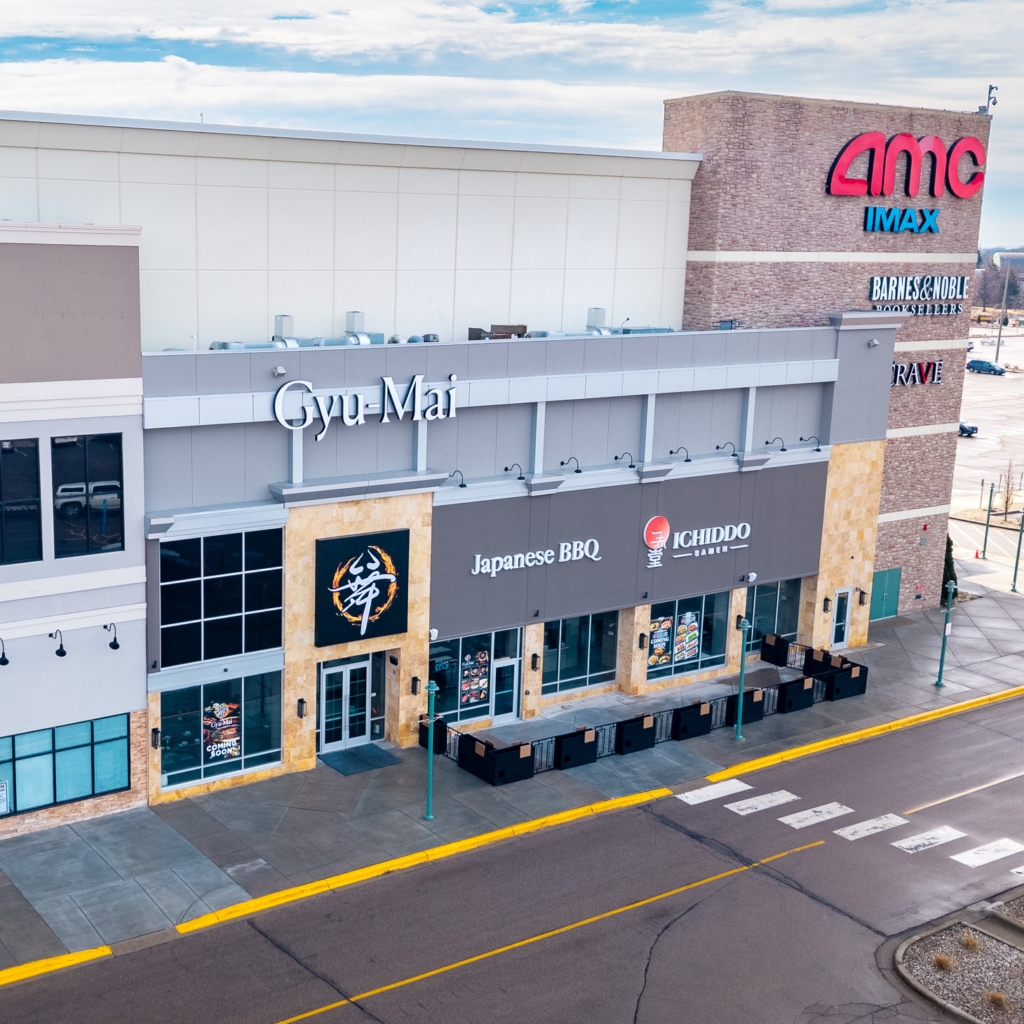 an aerial view of Gyu-Mai and Ichiddo Ramen restaurant facades in mall by parking lot