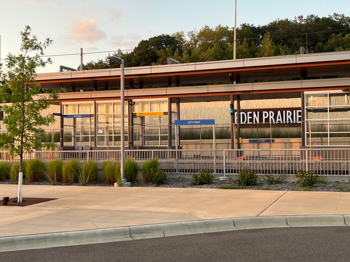 A light rail station with signs reading City West and Eden Prairie