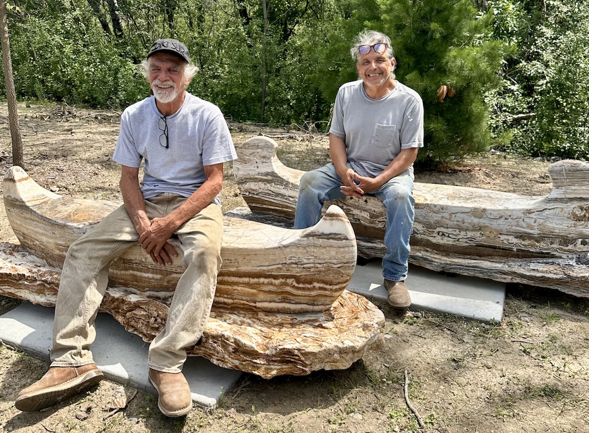 Artist Ramon Byrne (front) and sculptor Rude Calderon pause while installing canoes near the Fox and Grouse apartments.