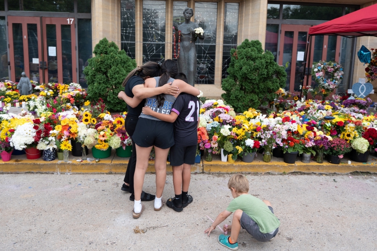 People embrace at a memorial outside Annunciation Church, the site of an Aug. 27 shooting during a Mass for Catholic school children, in Minneapolis on Sept. 2, 2025. Photo by REUTERS/Tim Evans