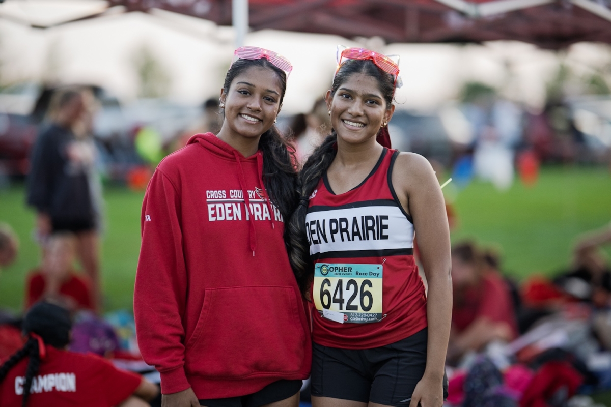 Eden Prairie seniors Zoya Hussain (left) and Dheekshitha Jayaprakash prepare to race at the Metro Invitational on Sept. 13 at Flying Cloud Fields. The annual meet, Minnesota’s largest, drew more than 2,000 runners and is known for its nighttime races under the lights.