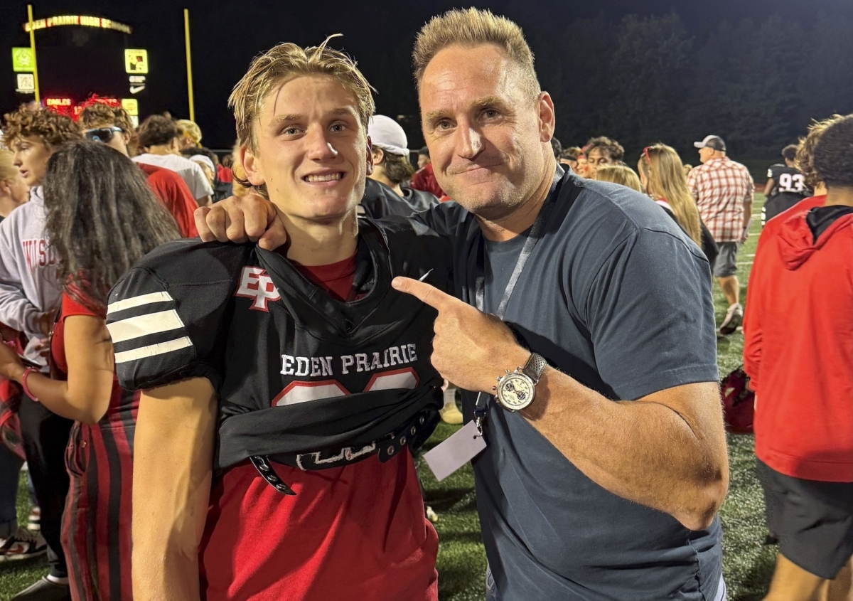 Mak Anderson, left, and his father, Erik, after Eden Prairie’s win over Edina on Sept. 12. Twenty-five years earlier, Erik wore the same No. 29 jersey when the Eagles captured the 2000 state championship. Photo by Ryan Sather