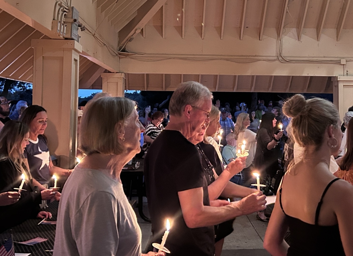 A group holds candles at dusk.