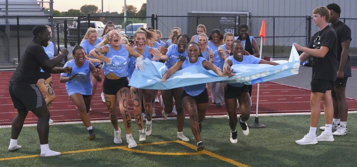 Eden Prairie High School sophomores run through a paper banner before their Powderpuff game at Aerie Stadium on Sept. 29, 2025.