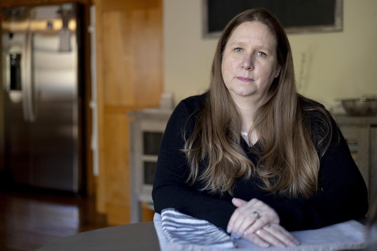 Beki Cook sits for a portrait at her home on Wednesday, Oct. 29, 2025, in St. Paul, Minn. Cook was diagnosed with hereditary angioedema in 2019, which causes unpredictable episodes of swelling in various parts of her body. The oral medication she takes everyday to keep her symptoms at bay costs about $1,600 per pill. Cook has insurance through MNsure, the state’s Affordable Care Act offshoot program. She pays about $1,000 for a top tier plan that features a lower out-of-pocket max to pay for her medications.