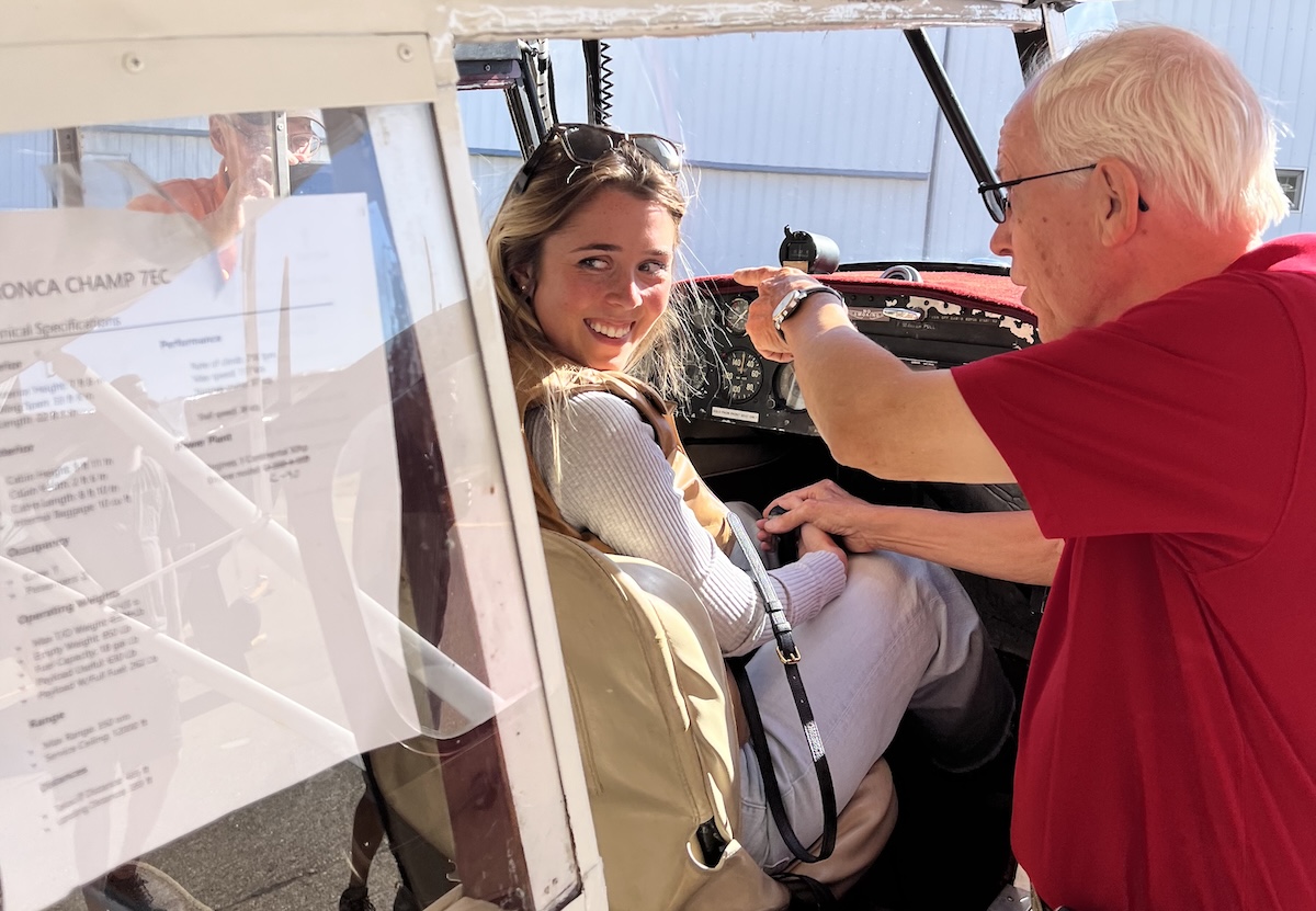 Katelyn Larson of Chanhassen smiles from the cockpit of a 1950 Aeronca Champion at Flying Cloud Airport as Wings of the North Museum director Bob Jasperson points out features of the plane she won in the Sept. 27 sweepstakes.