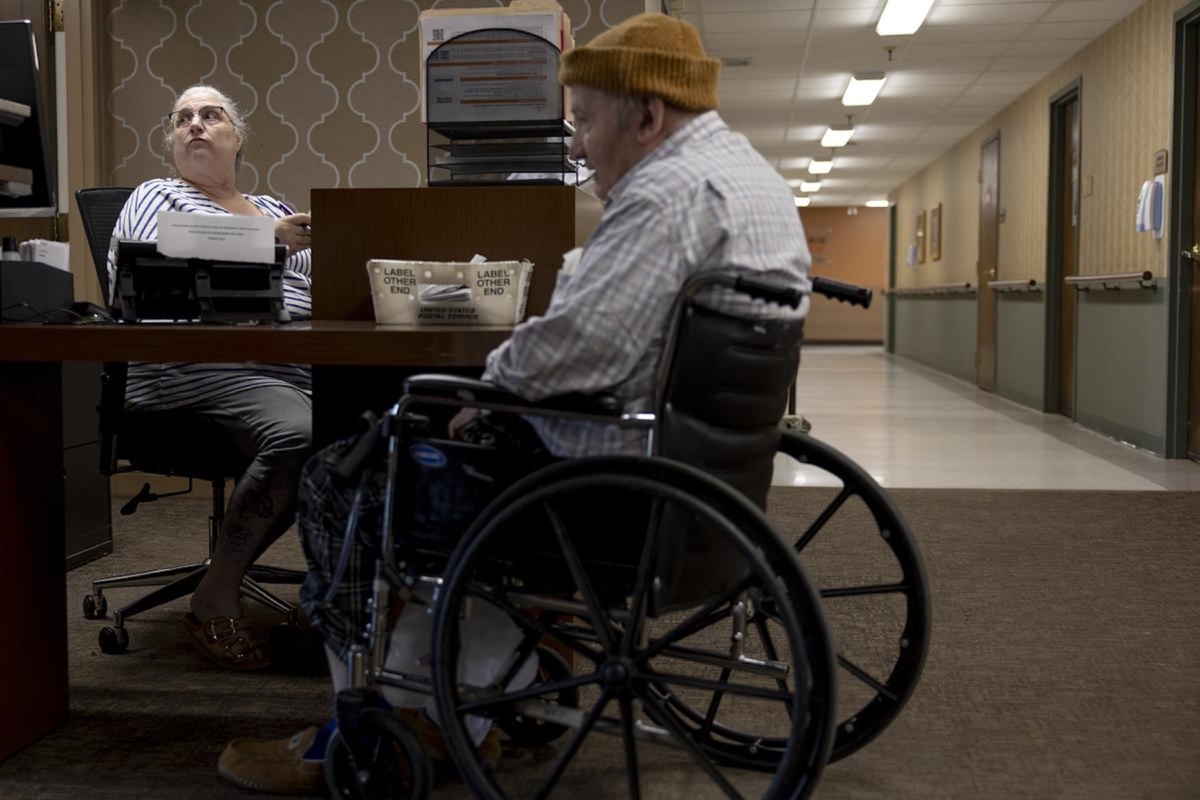 Receptionist Mary Voerding helps a client at the Maplewood Rehabilitation Center on Tuesday, Sept. 30, 2025, in Maplewood, Minn. Voerding has worked at the facility for 30 years in several different capacities, and plans to retire in her role.