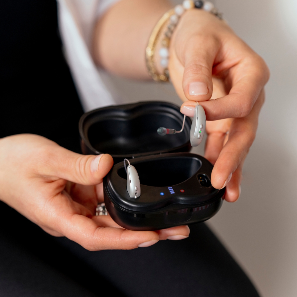 a woman holds a box containing hearing assistance devices