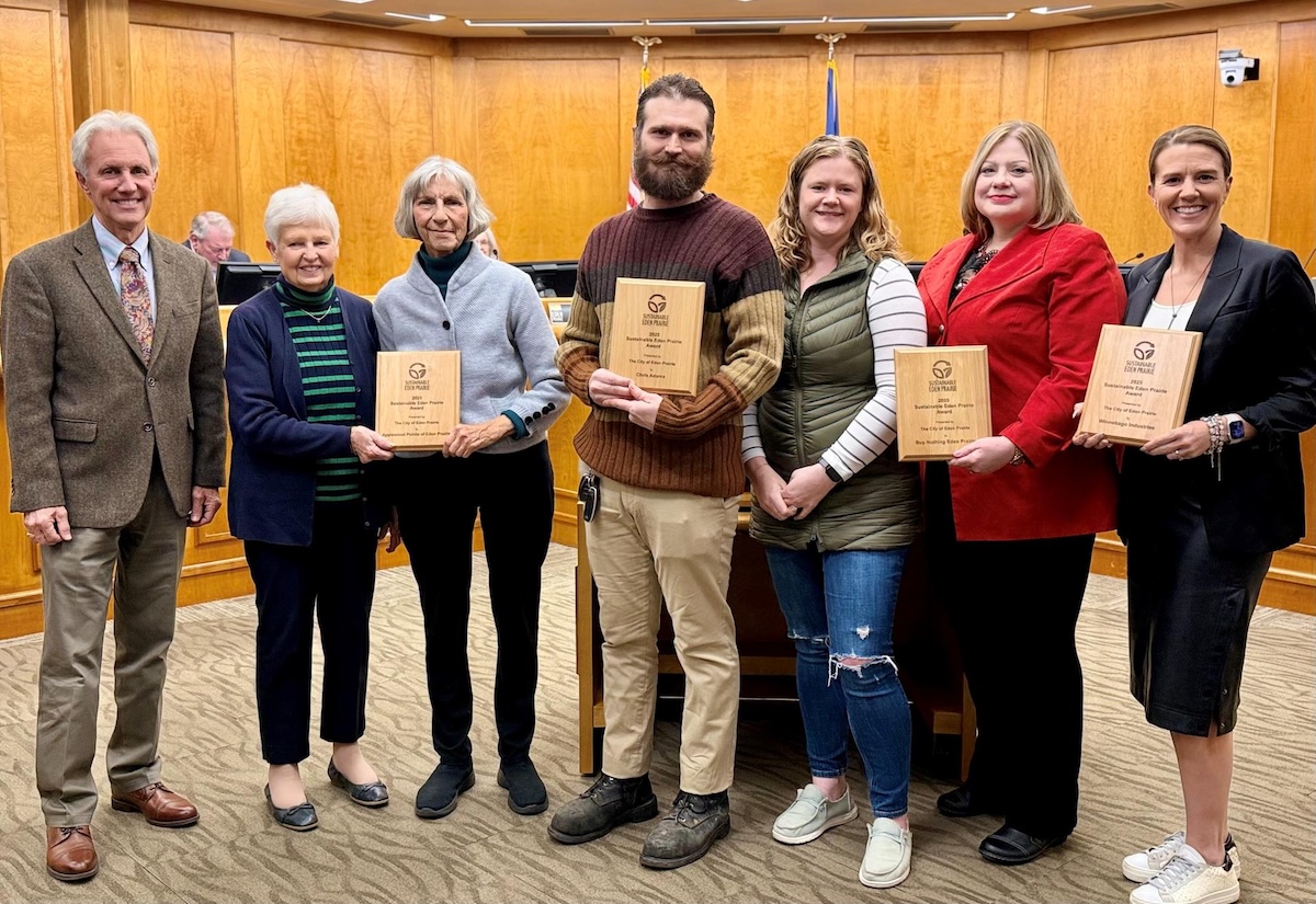 From left: Mayor Ron Case; representatives of Applewood Pointe; Chris Adams; representatives of Buy Nothing Eden Prairie; and a representative of Winnebago Industries stand for a photo at the Nov. 18 City Council meeting after being recognized as 2025 Sustainable Eden Prairie Award winners.