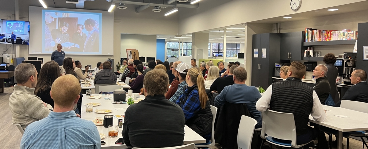 group of people, seen from the back, in conference room watch a slide presentation