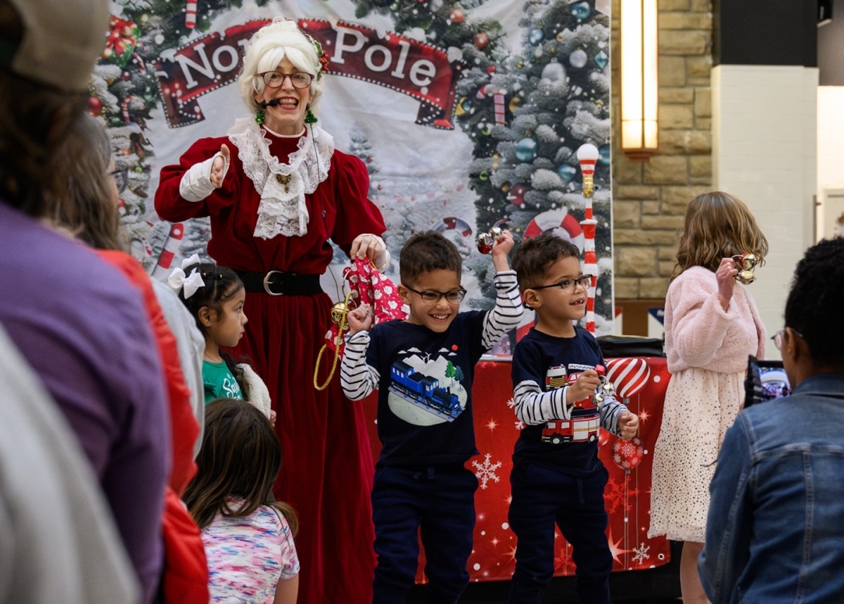 Children ring bells with Mrs. Claus during a holiday event at Eden Prairie Center.