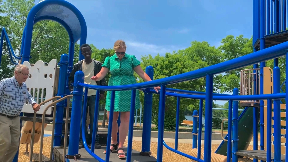 Photo of Jim Knopf, Bonnly Odhiambo and Eden Prairie Parks Director Amy Markle boarding a safe but wobbly elevated walkway.