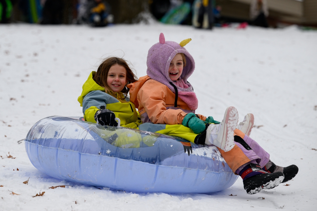 Hazel Kidd, wearing a unicorn hat, and Jorie Hendrickson sled down the Staring Lake hill after the season’s first significant snowfall.