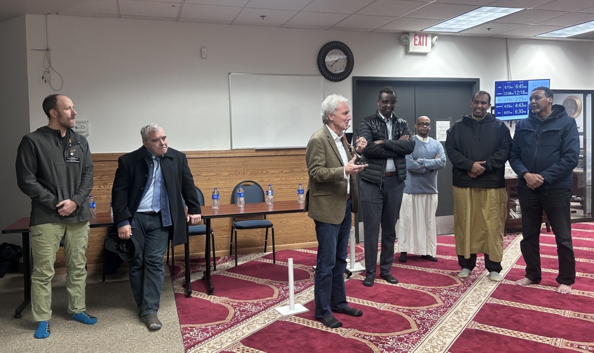 A group of men stand on a red carpet.