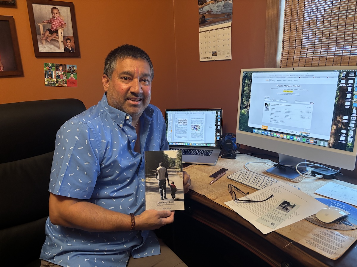Brian Wilson holds a copy of his memoir, “Climbing Clouds: An Immigrant’s American Story,” in the living room of his Eden Prairie home.