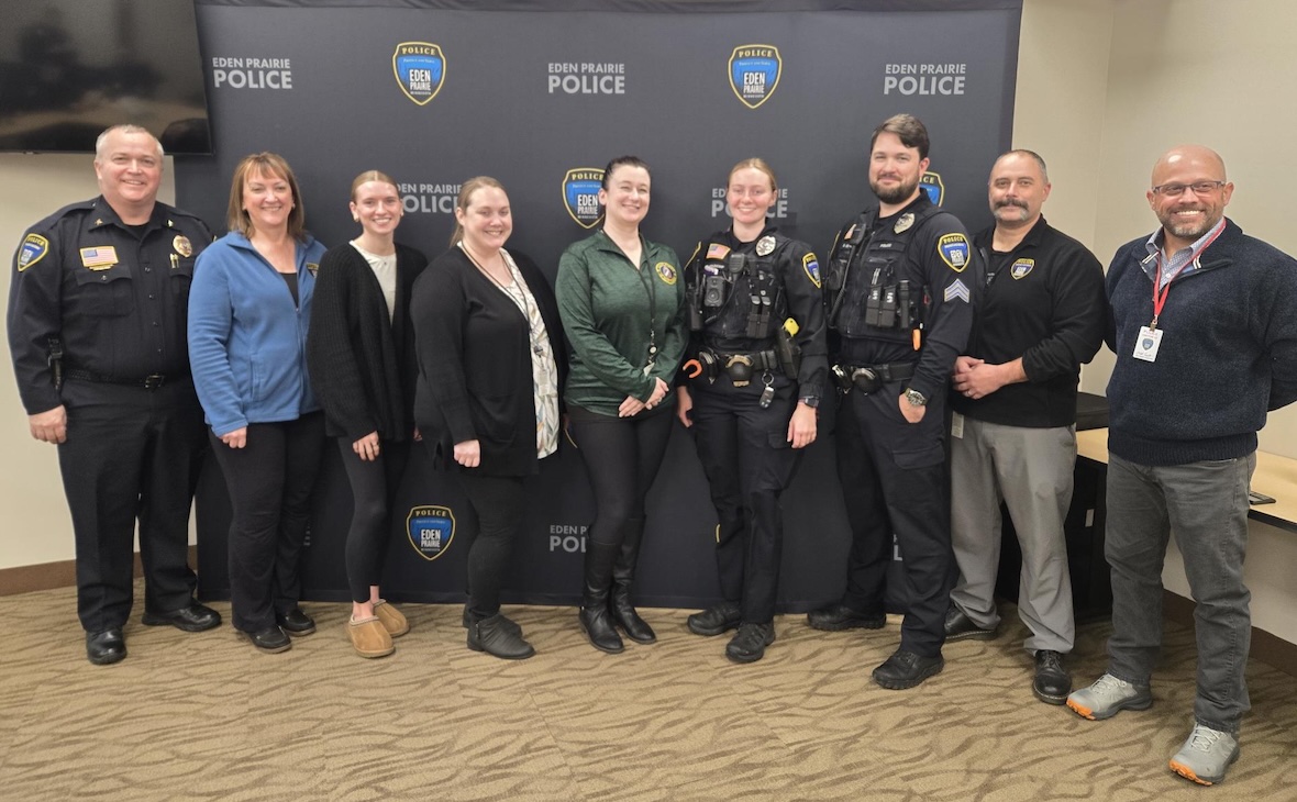Group photo of Eden Prairie Police Chief Matt Sackett, several EPPD staff members, and Jason Daughrity of 3SI standing in front of an Eden Prairie Police backdrop.